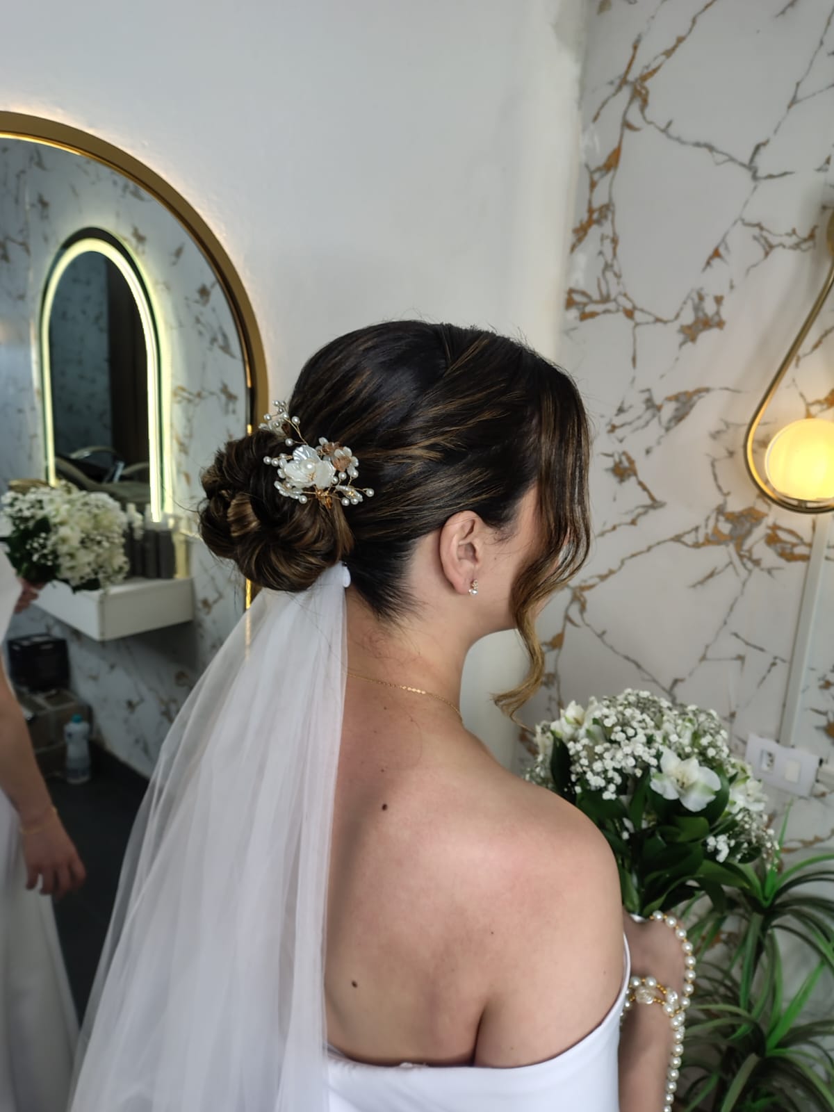 Penteado de noiva com coque, acessório floral e véu, por Yasmim Vieira